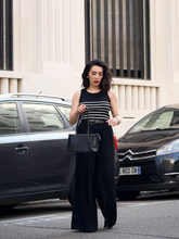 a lady wears a striped tank top with black wide leg pants